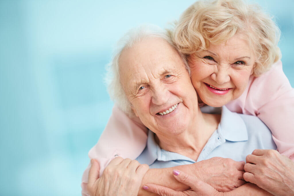 Happy elderly couple holding eachother